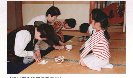 文化祭のお茶席で、お点前をする人と客をもてなす人々の写真